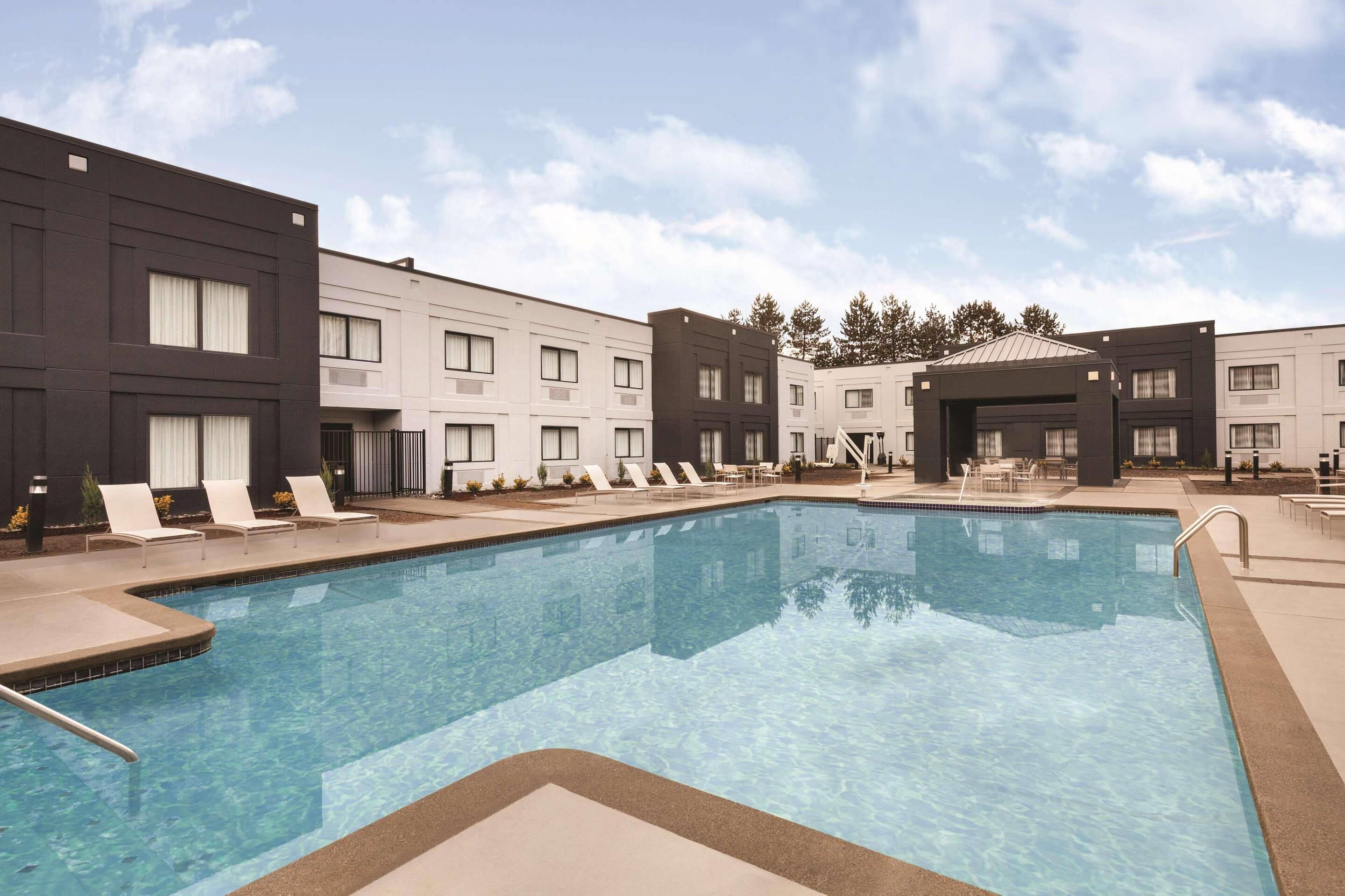 Una piscina al aire libre de temporada, tumbonas