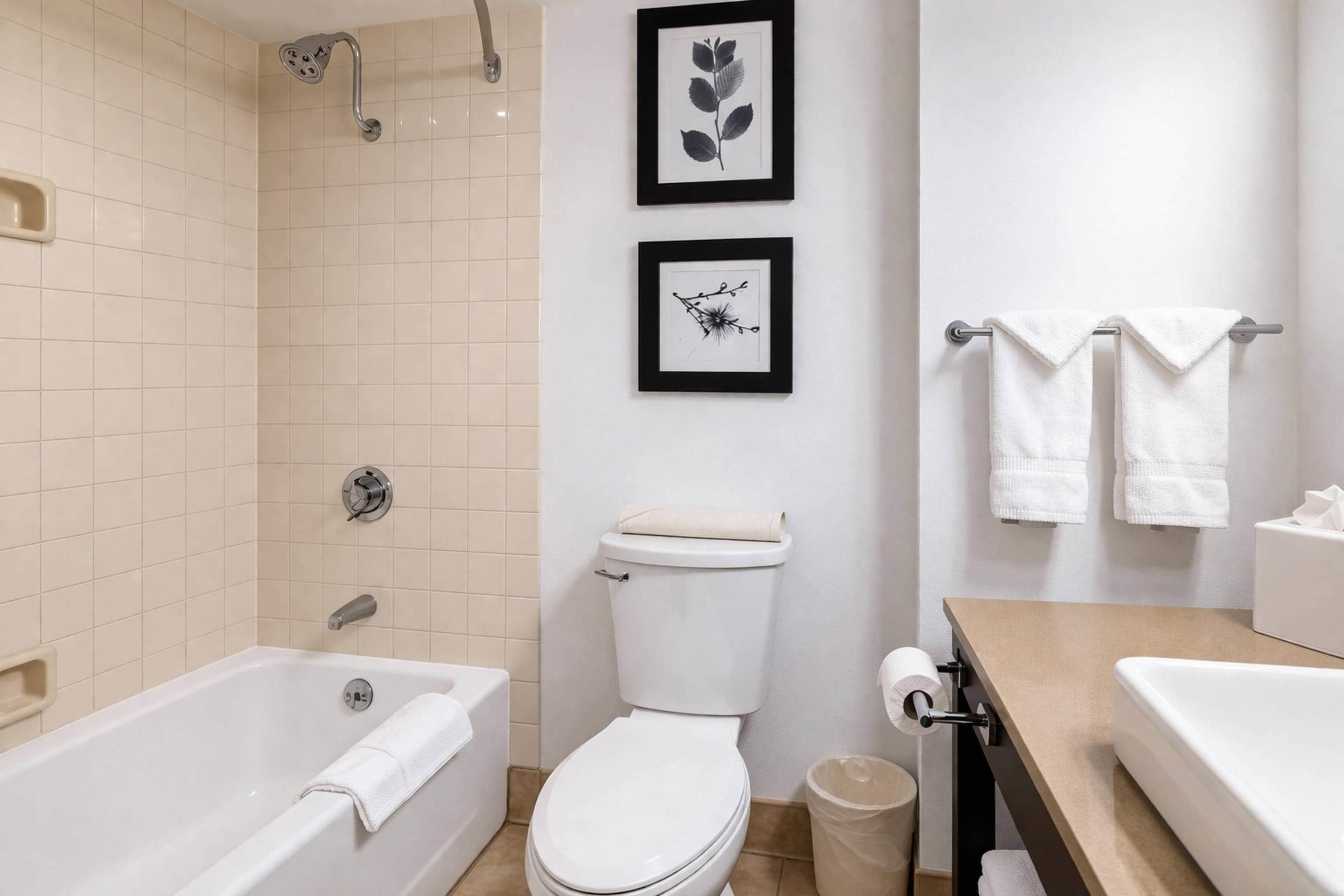 A bathroom with a bathtub, toilet, and sink.