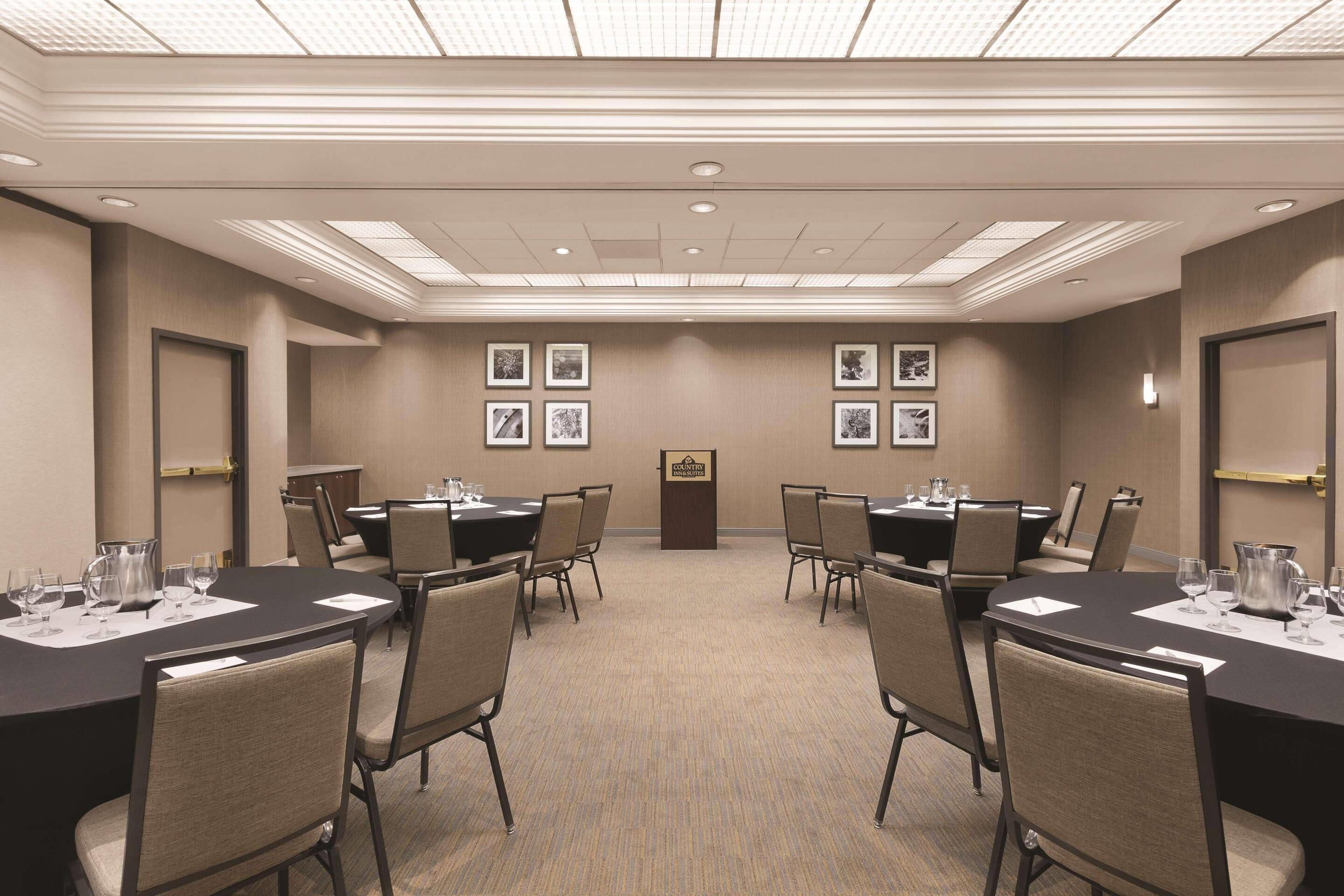 A conference room with a long table, chairs, and a podium.