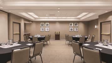 A conference room with a long table, chairs, and a podium.