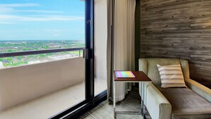 Un balcón con vistas a un paisaje urbano, un sofá, una mesita y una pared de madera.