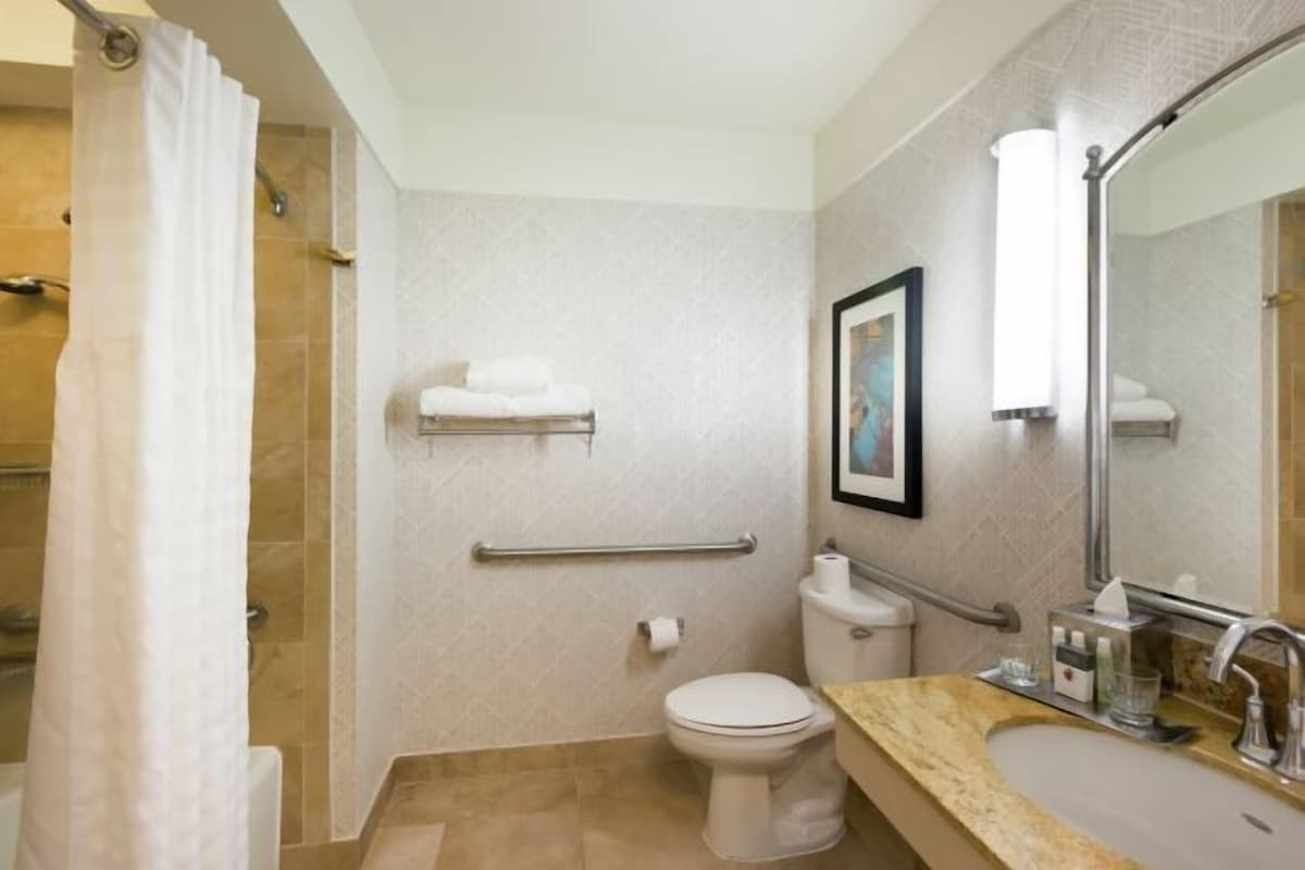 A bathroom with a toilet, sink, and shower area.
