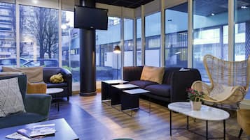A modern lounge area with a sofa, armchairs, a coffee table, and a fireplace.