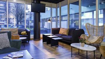 A modern lounge area with a sofa, armchairs, a coffee table, and a fireplace.