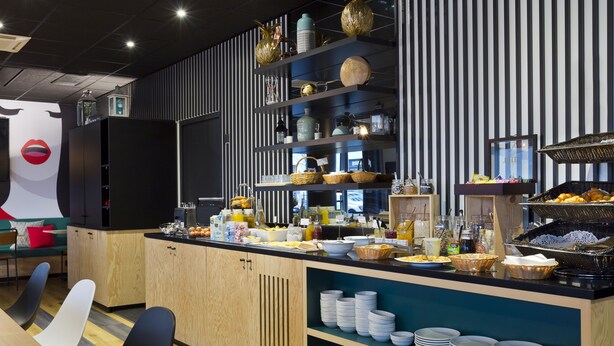 Une cuisine moderne avec un buffet proposant divers plats et assortiments de vaisselle.