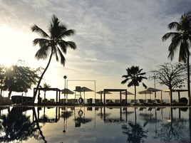 Una piscina al aire libre, sillones reclinables de piscina
