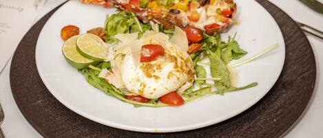 A plate with a grilled fish, a poached egg, and a salad.