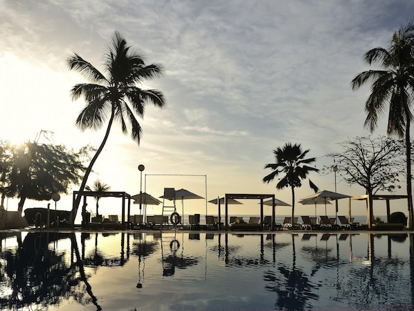 Una piscina al aire libre, sillones reclinables de piscina