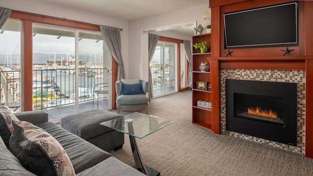 A living room with a sofa, a glass coffee table, a fireplace, and a TV.