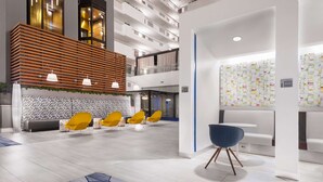 Un hall d'hôtel moderne avec un mur en lambris de bois, des chaises jaunes, une chaise bleue et un mur à motifs.
