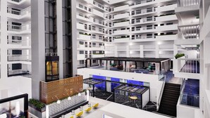 Un atrium à plusieurs niveaux, doté d’un espace central ouvert, de balcons et de divers espaces aménagés pour s’asseoir.