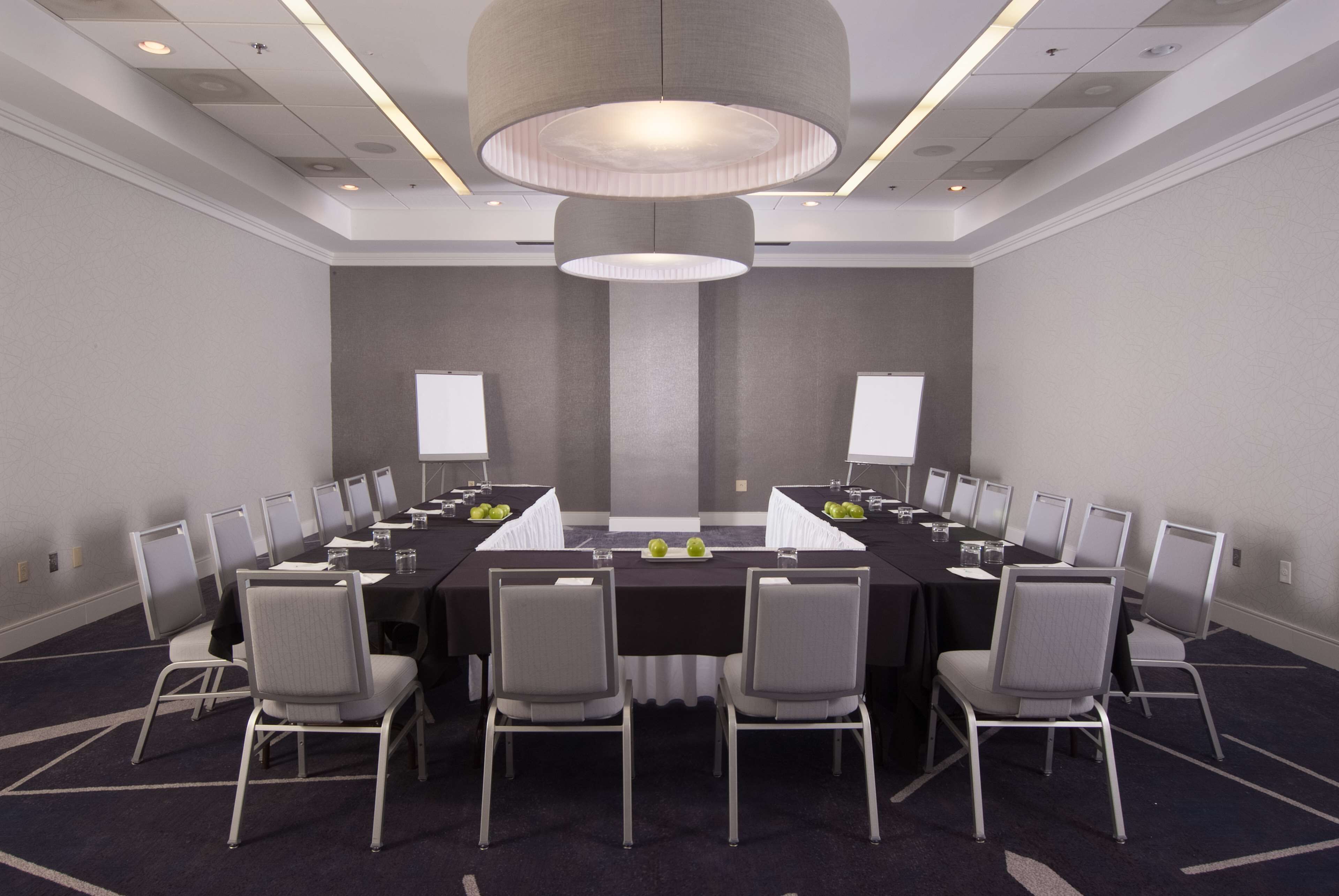 Un salón de conferencias con una larga mesa, sillas y una gran lámpara de araña.