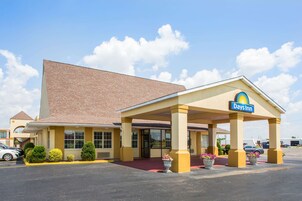 Un Days Inn con fachada de ladrillo, entrada cubierta y estacionamiento.