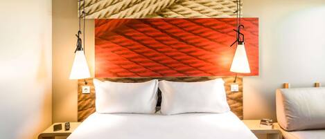 A neatly made bed with white linens, two bedside tables with lamps, and a textured wall above the bed.