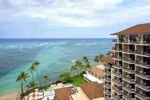 A hotel with multiple balconies overlooking a beach and ocean. - Halekulani (Honolulu)