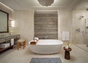 A modern bathroom with a freestanding bathtub, a glass-enclosed shower, and a vanity with a mirror.