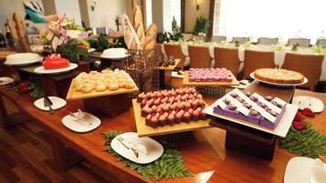 Una mesa de buffet con diversos postres y pasteles.