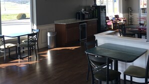 A spacious room with a large window, a kitchenette, and a dining area with chairs and a table. - Travelodge by Wyndham Gallipolis (Gallipolis)