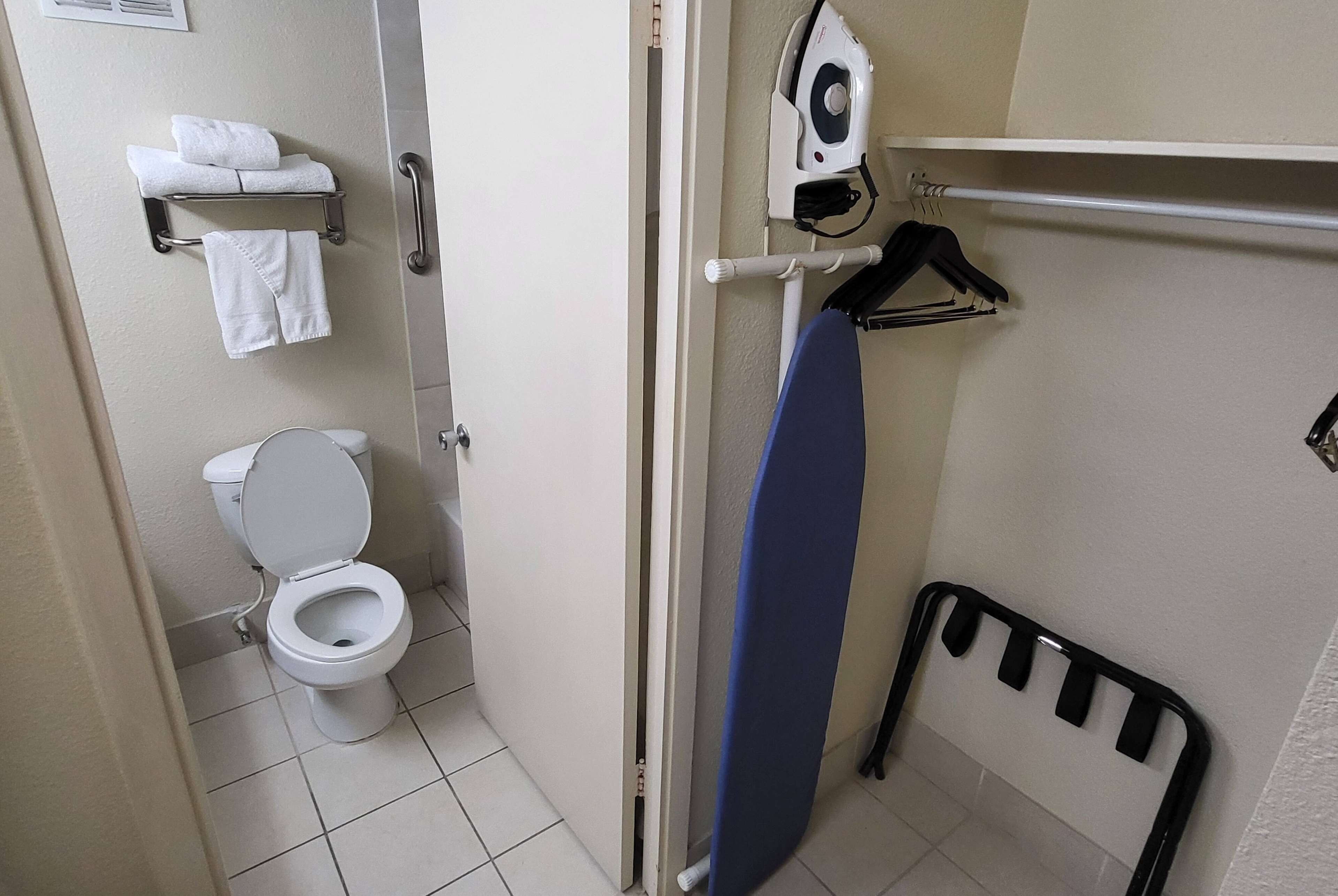 Une salle de bain comprenant des toilettes, un porte-serviettes avec des serviettes pliées, un sèche-cheveux et un radiateur.