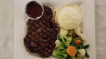 A plate with a steak, mashed potatoes, and a side of mixed vegetables.