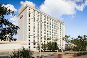 Un hotel de varios pisos con fachada blanca y el logotipo visible de Hilton Garden Inn.