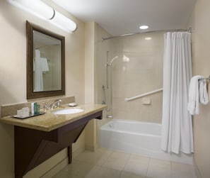 Ein Badezimmer mit Waschbecken, Spiegel und Dusche.