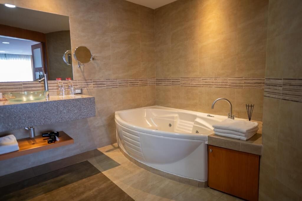 A modern bathroom with a freestanding bathtub, a vanity with a mirror, and a towel rack.