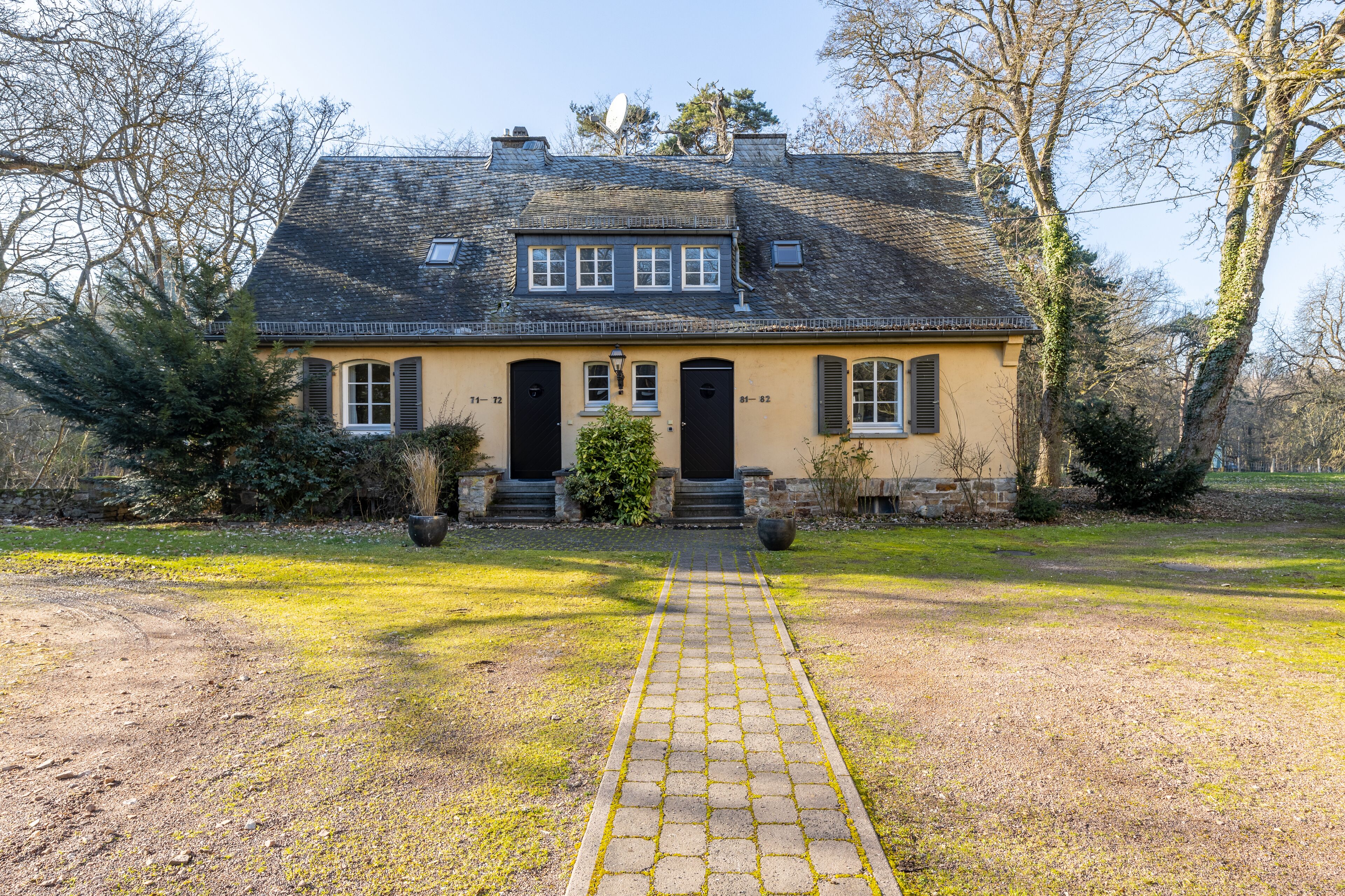 Et toetagers hus med en belagt indkørsel, der fører til indgangen.
