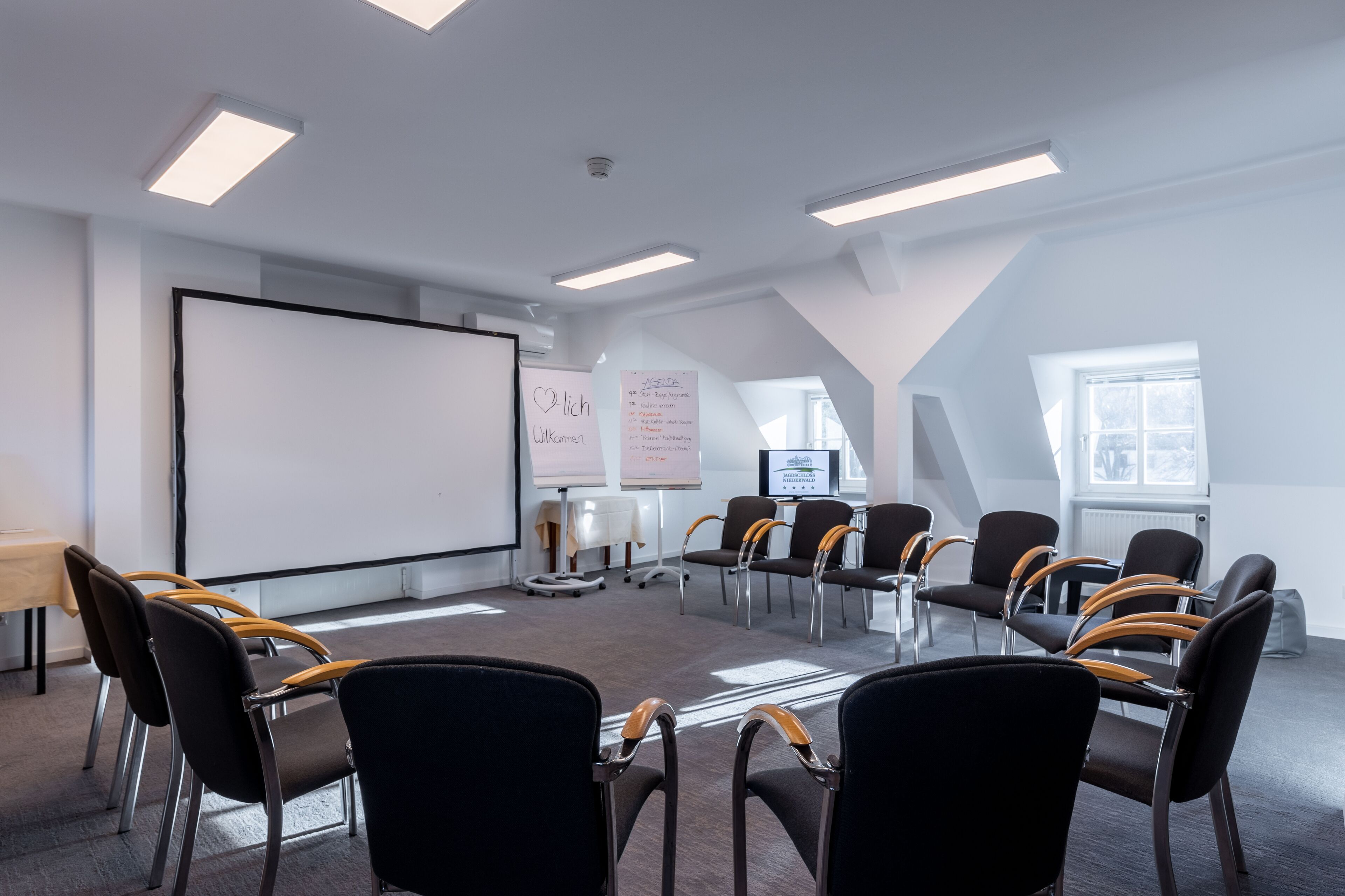 A conference room with a whiteboard, projector, and seating arrangement.