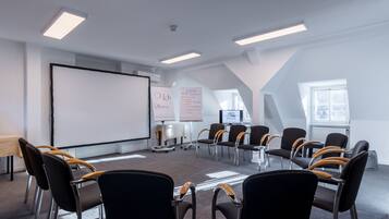 A conference room with a whiteboard, projector, and seating arrangement.