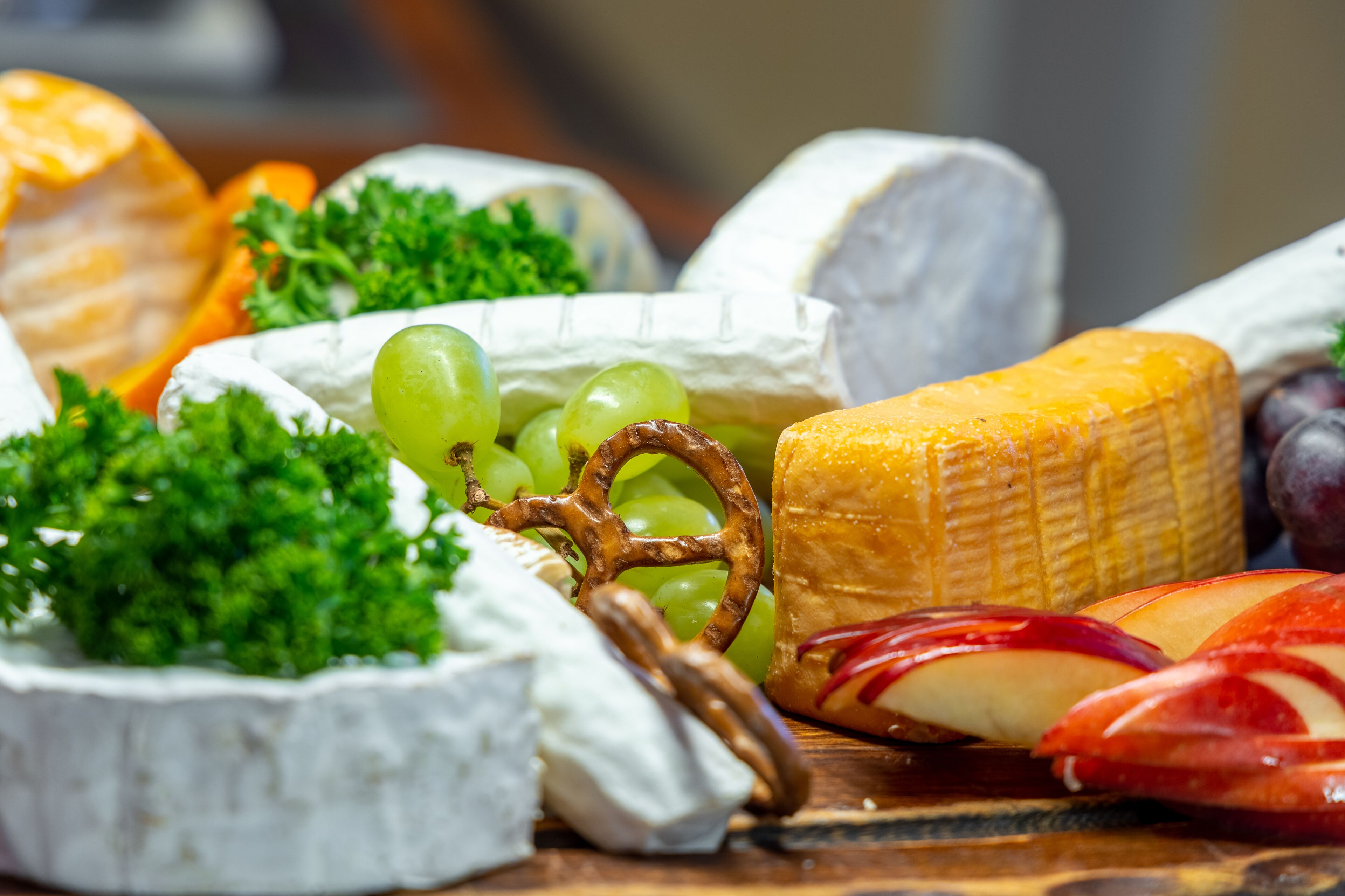 Eine Auswahl an Käse und Obst auf einem Holzbrett.