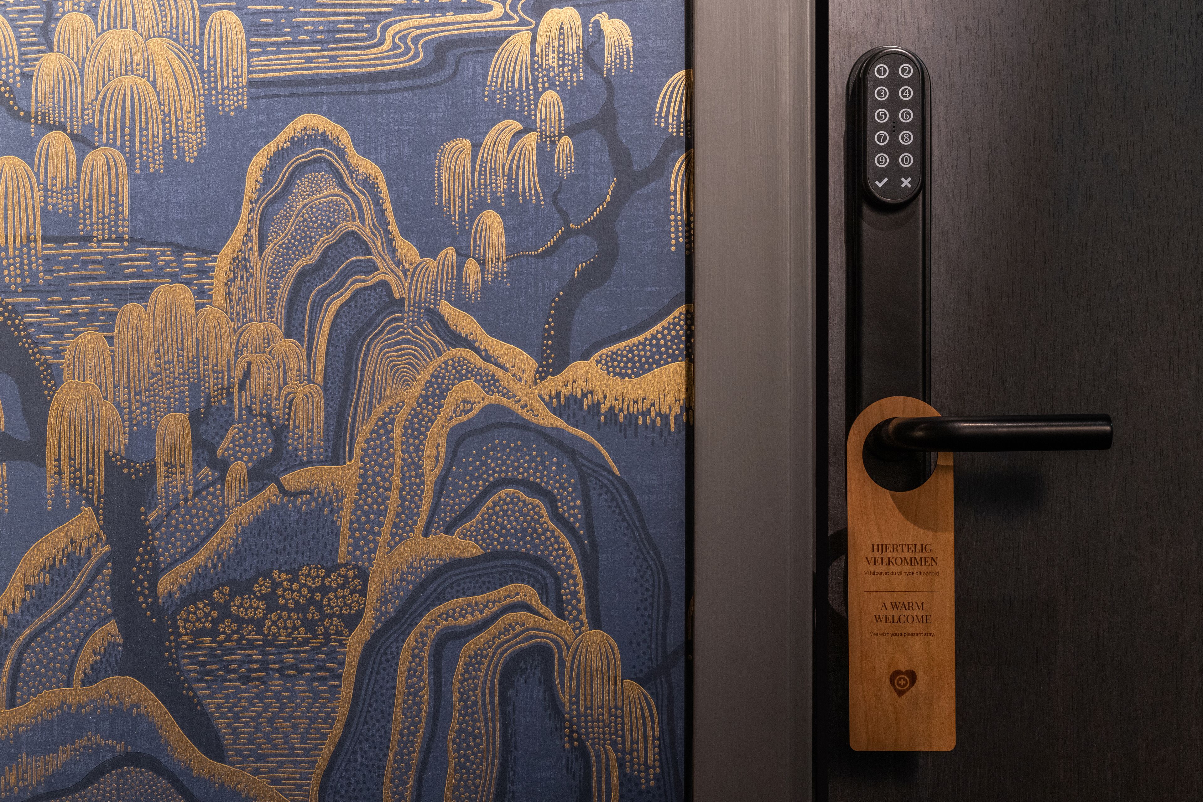 Porta com entalhe tradicional em madeira japonesa e fechadura eletrônica moderna.