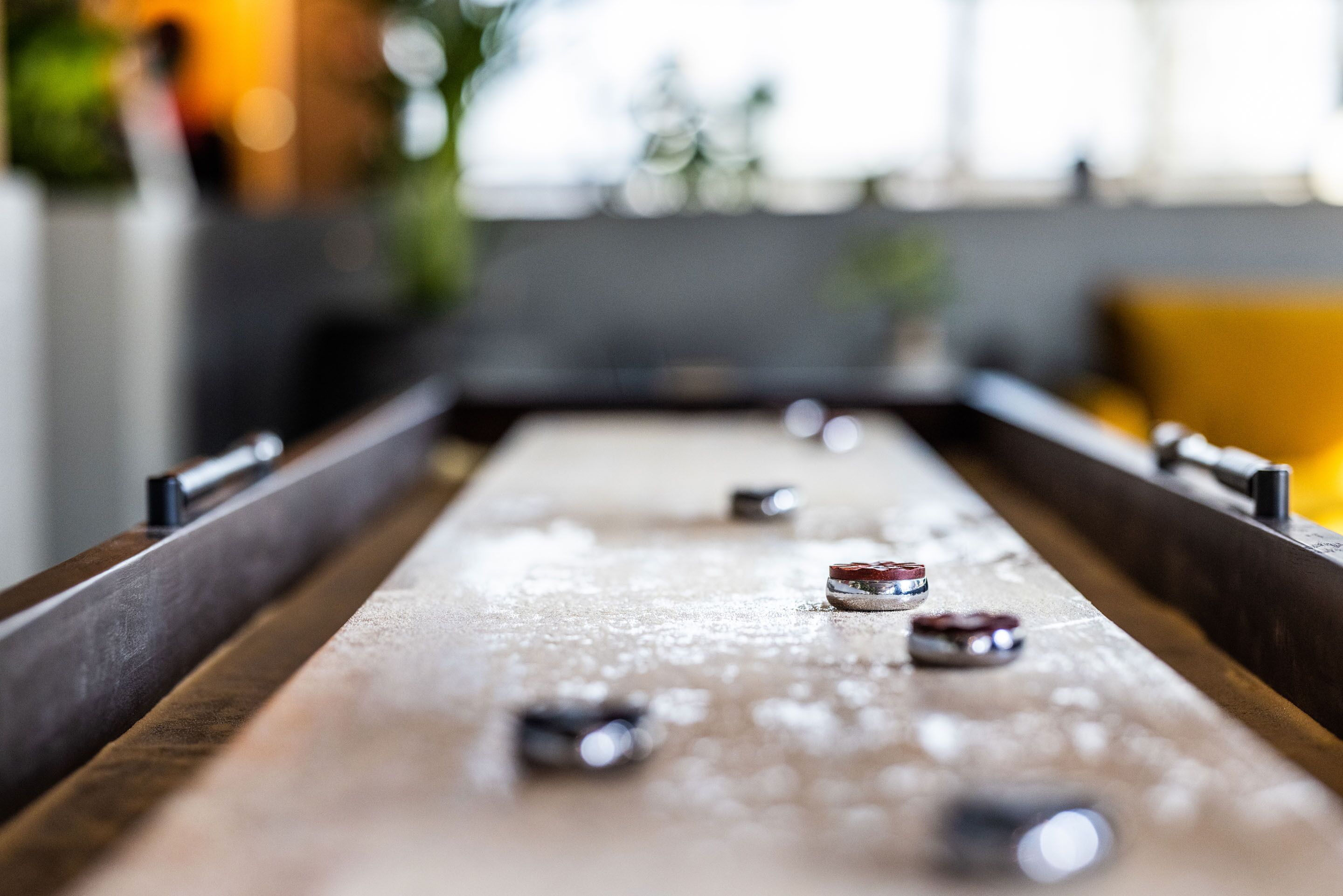 Primer plano de una mesa de shuffleboard con las fichas en el punto de enfoque.