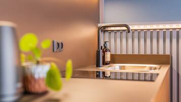 A modern kitchen with a sink, a faucet, and a bottle of hand soap.