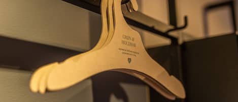 A wooden hanger with text, hanging on a metal rod.