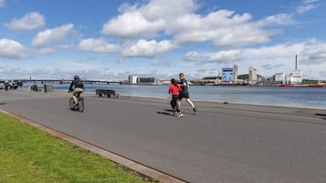 Een verhard pad langs de waterkant, met fietsers en voetgangers.