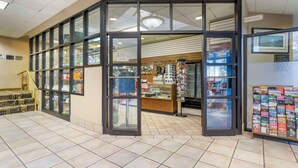 A store with a glass door entrance, a Pepsi refrigerator, and a display of travel brochures.