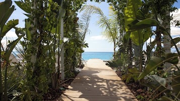 Plage privée, sable blanc, cabines (en supplément), chaises longues