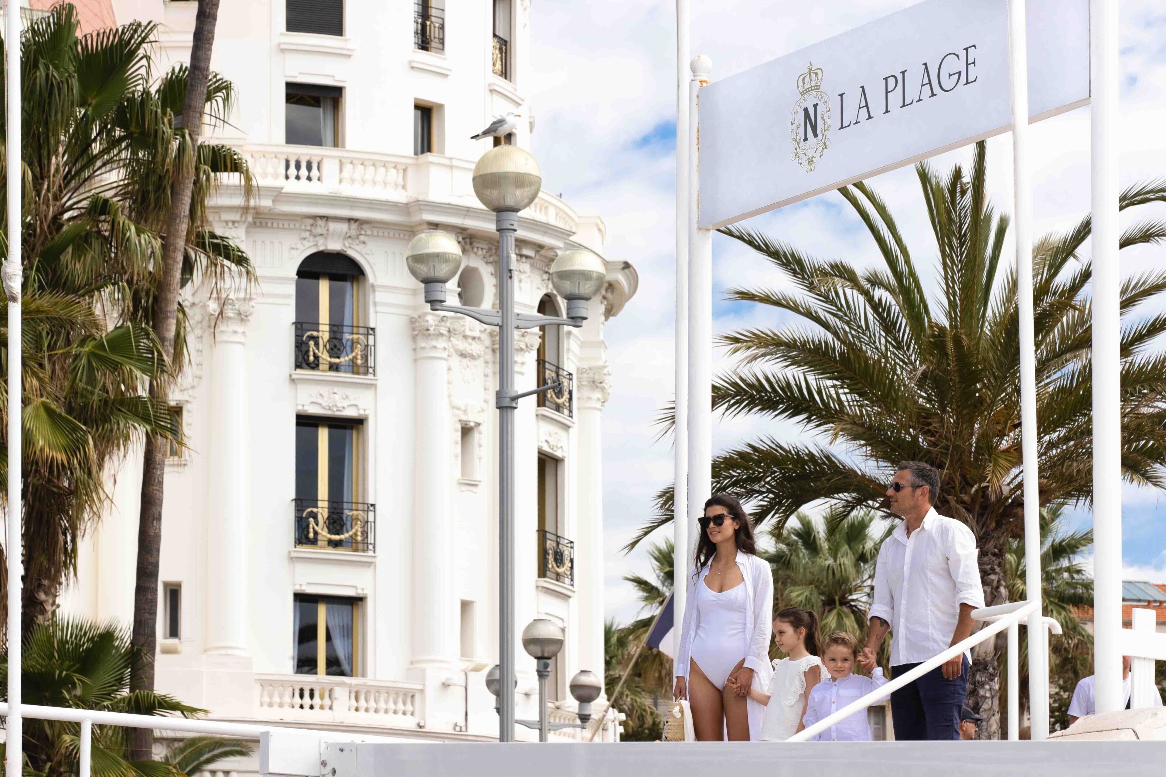 Un edificio con balcones ornamentales y un letrero que dice "N LA PLAGE".