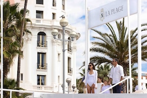 A building with ornate balconies and a sign reading "N LA PLAGE".