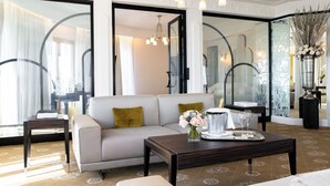 Una habitación de hotel moderna con un sofá, una mesita de centro y un florero con flores.
