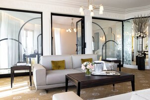 Une chambre d’hôtel moderne, équipée d’un canapé, d’une table basse et d’un vase de fleurs.