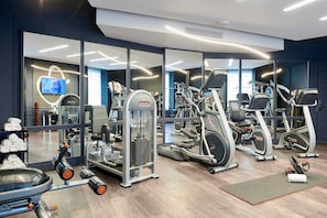 A modern gym with various exercise equipment, including treadmills and weight machines, and a large mirror wall. - Hotel Le Negresco (Nice)