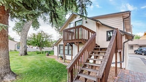 A two-story house with a wooden staircase leading to a balcony. - Best Western Sunset Inn (Cody)