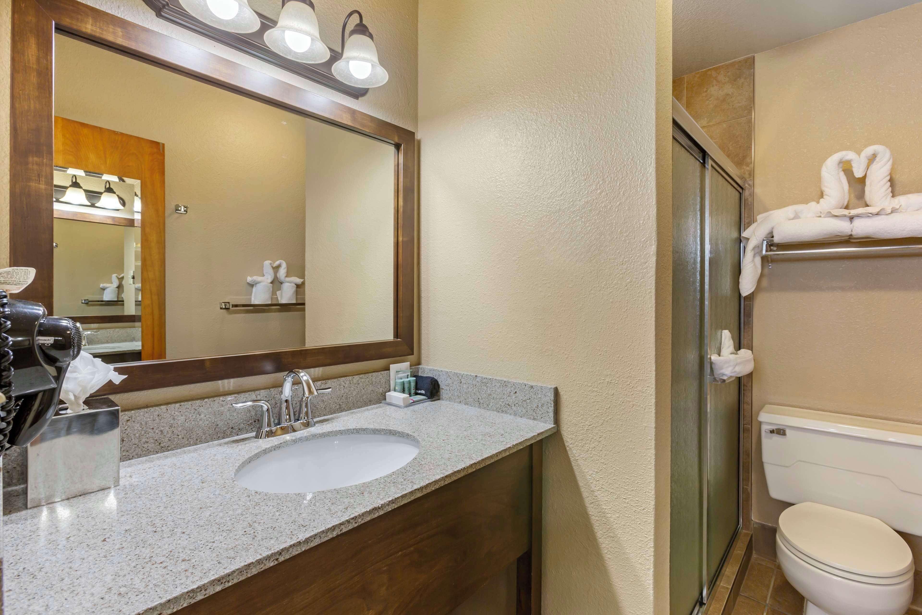 A bathroom with a sink, mirror, and towel rack.
