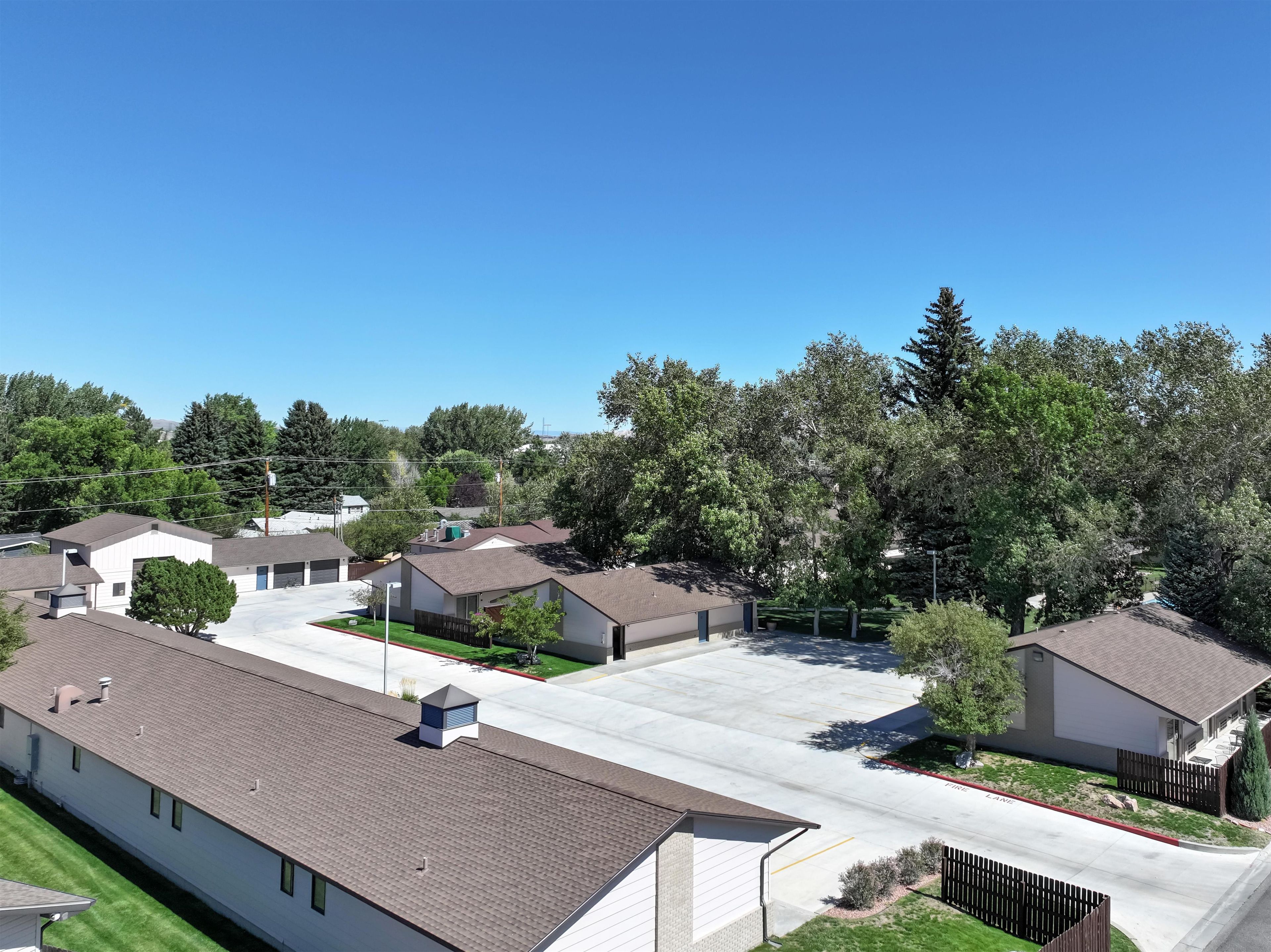 Un quartier résidentiel composé de maisons individuelles, avec un ciel dégagé et une pelouse bien entretenue.