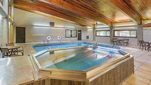 A swimming pool with a wooden ceiling, tiled walls, and seating areas. - Best Western Sunset Inn (Cody)