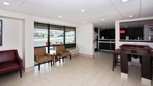 A clean, modern interior with a seating area, a counter, and a view of the street outside.