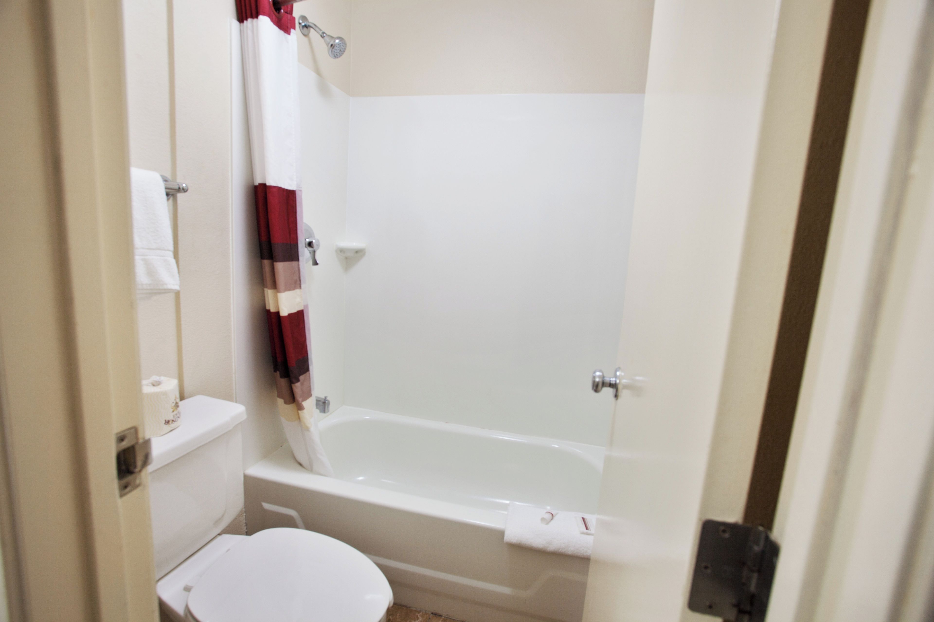 A bathroom with a toilet, a bathtub, and a shower curtain.
