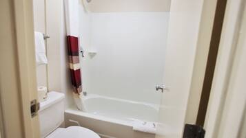 A bathroom with a toilet, a bathtub, and a shower curtain.